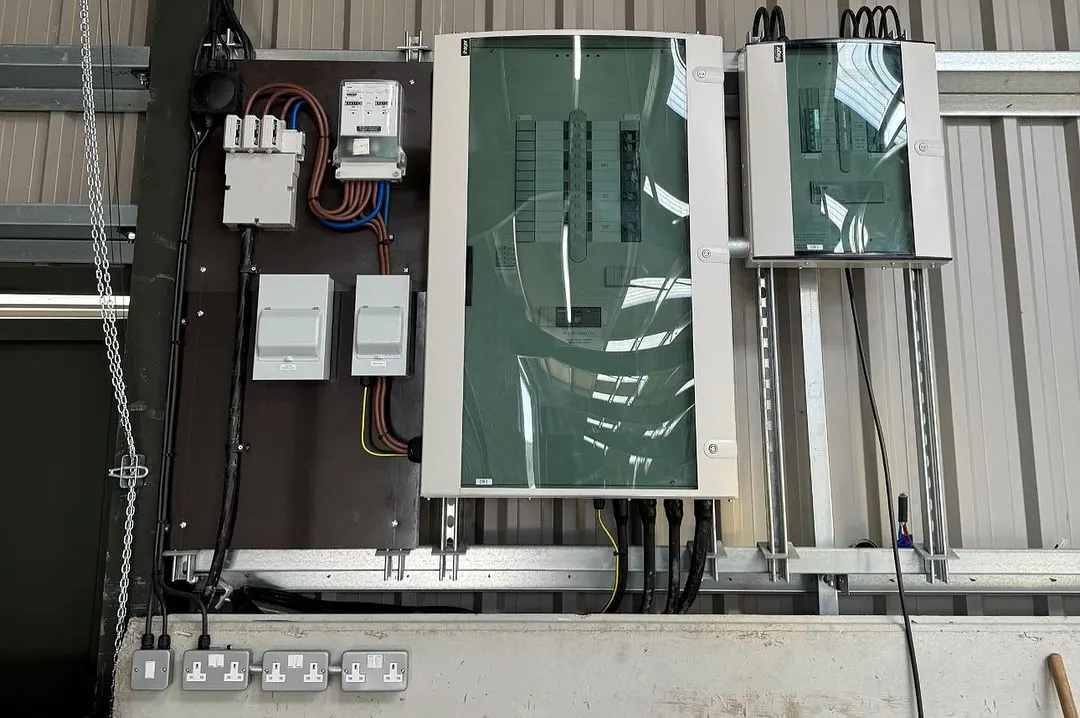Distribution boards and isolators mounted on a backboard in a steel-framed building
