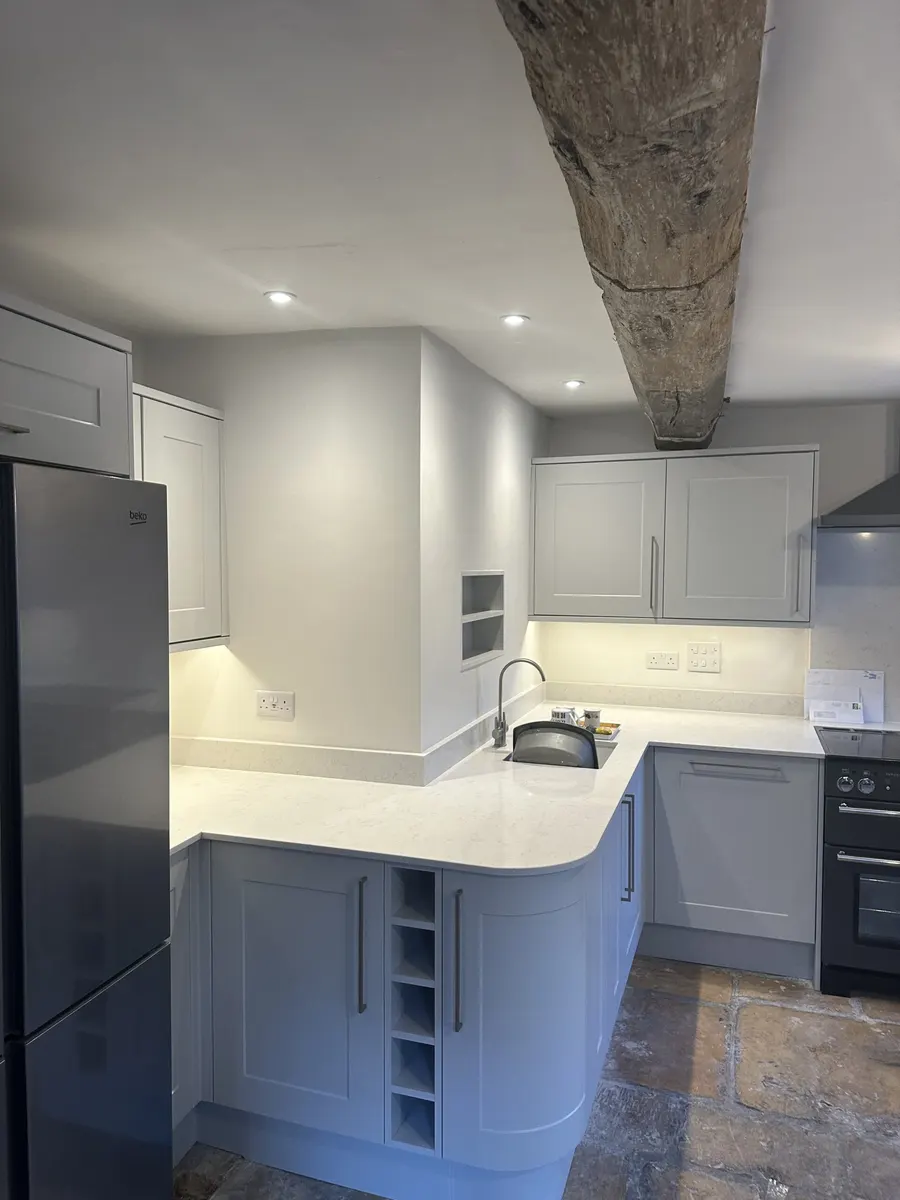 Finished cottage kitchen with an exposed oak beam, downlights, sockets and under-cabinet lighting