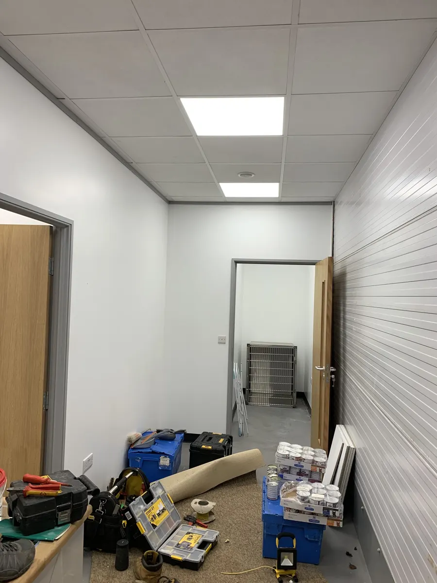 Corridor during fit-out, LED panels in, tools on the floor