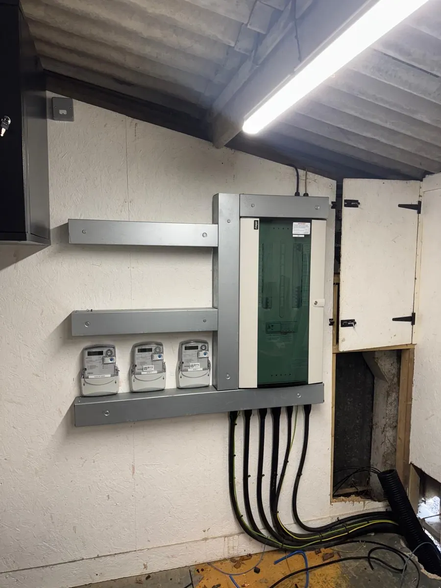 Hager distribution board with three meters on a metal trunking frame, supply cables dressed up to the board