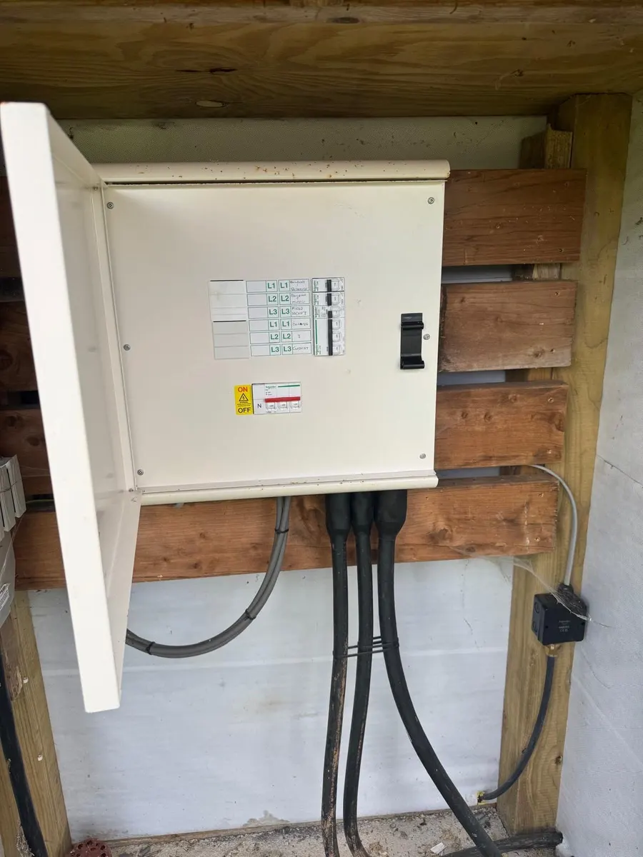 Control panel in a timber shelter with labelled ways, main switch and thick armoured cables coming in from below